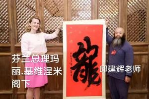 芬兰前总理玛丽-基维涅米与邱建辉（男）老师在赠送国礼书画仪式
